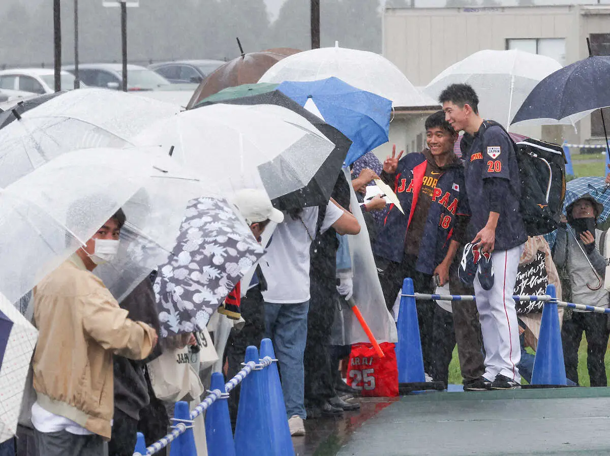 ＜侍ジャパン合宿　4日目＞雨が降る中、待っていたファン一人一人とふれあう戸郷（撮影・岸　良祐）　