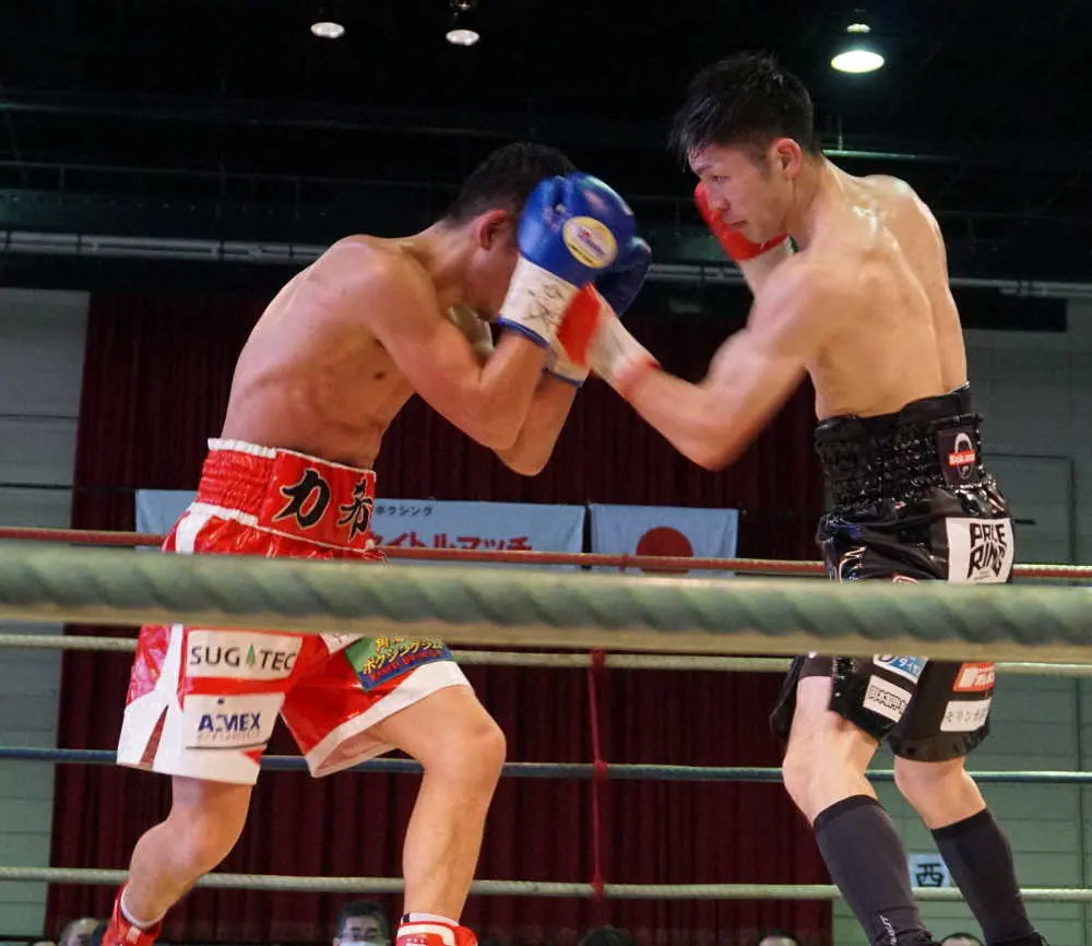 接近戦で粉川拓也（左）へ左アッパーを放つユーリ阿久井政悟