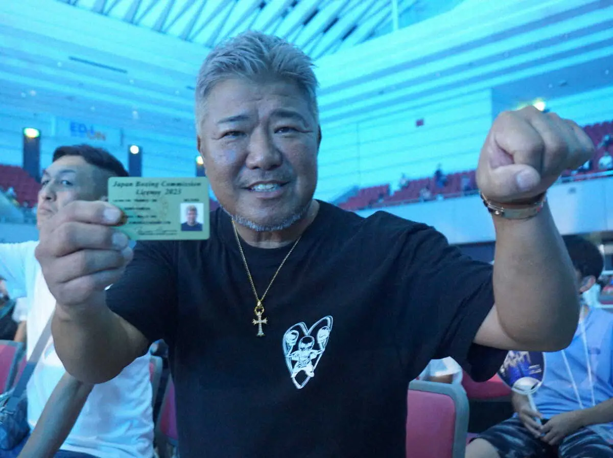 交付されたライセンスを手にポーズを決める亀田史郎トレーナー