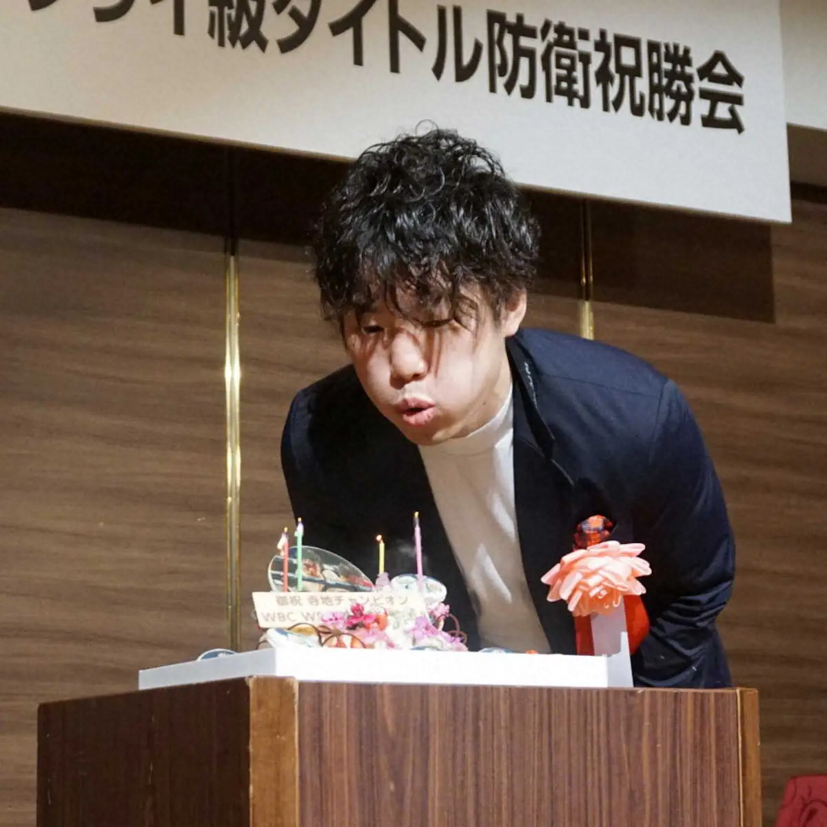 4団体統一を目指し、ケーキに立てられた4本のローソクの火を吹き消す寺地拳四朗