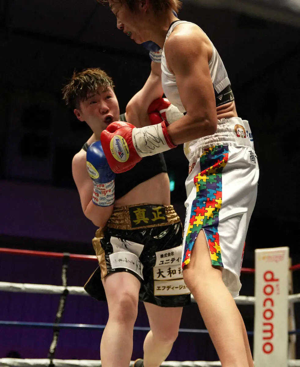＜IBF女子世界アトム級タイトルマッチ　岩川美花・山中菫＞岩川（右）にパンチを浴びせる山中（撮影・沢田　明徳）