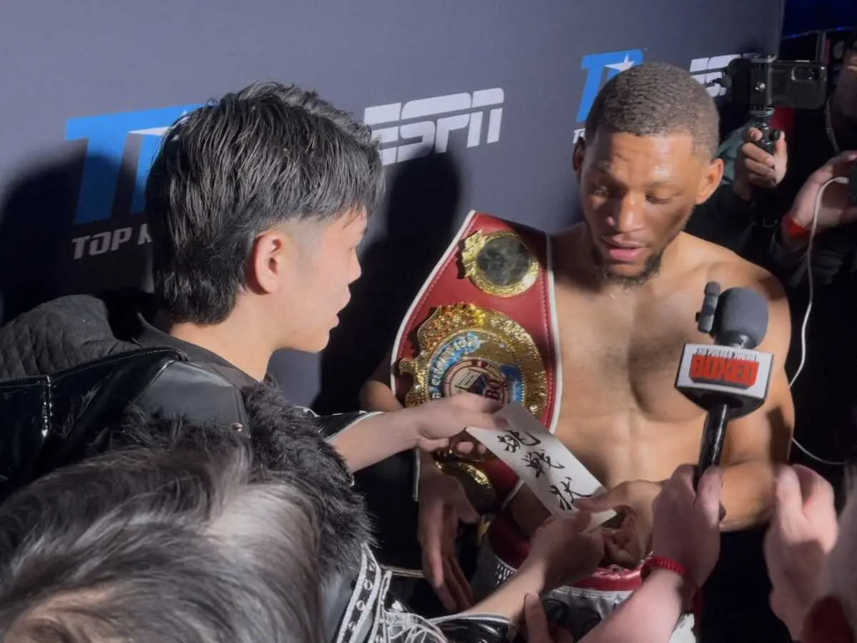 WBO世界ウェルター級タイトル戦でKOで防衛した王者ブライアン・ノーマンjr（右）に挑戦状を渡す佐々木尽（八王子中屋ジム提供）