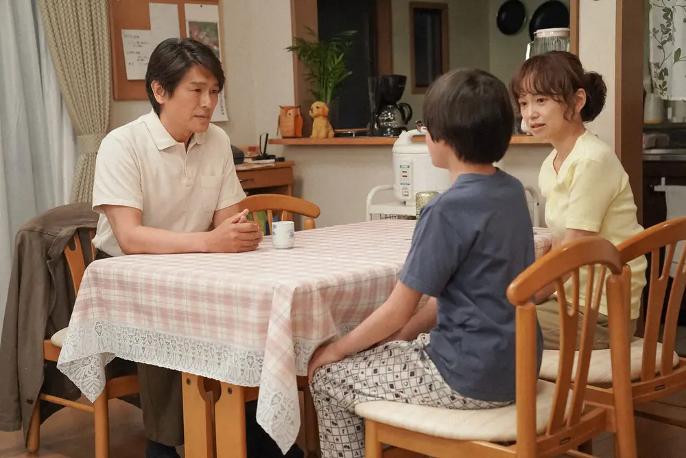 連続テレビ小説「舞いあがれ!」 第13話。 岩倉家・リビングにて。岩倉浩太（高橋克典・左）からあることを言われる岩倉悠人（海老塚幸穏・中央）を見つめる岩倉めぐみ（永作博美）（C）NHK