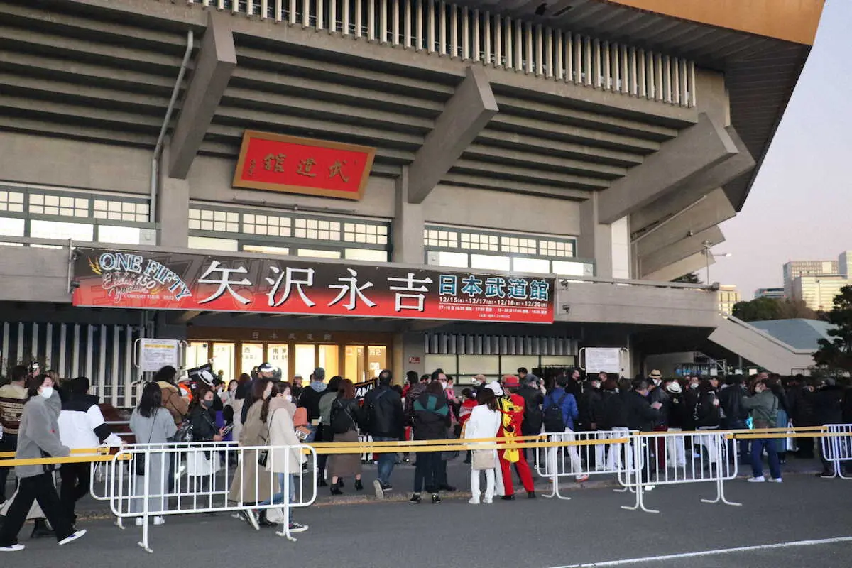 ライブが行われる予定だった日本武道館前で記念撮影をするファンたち