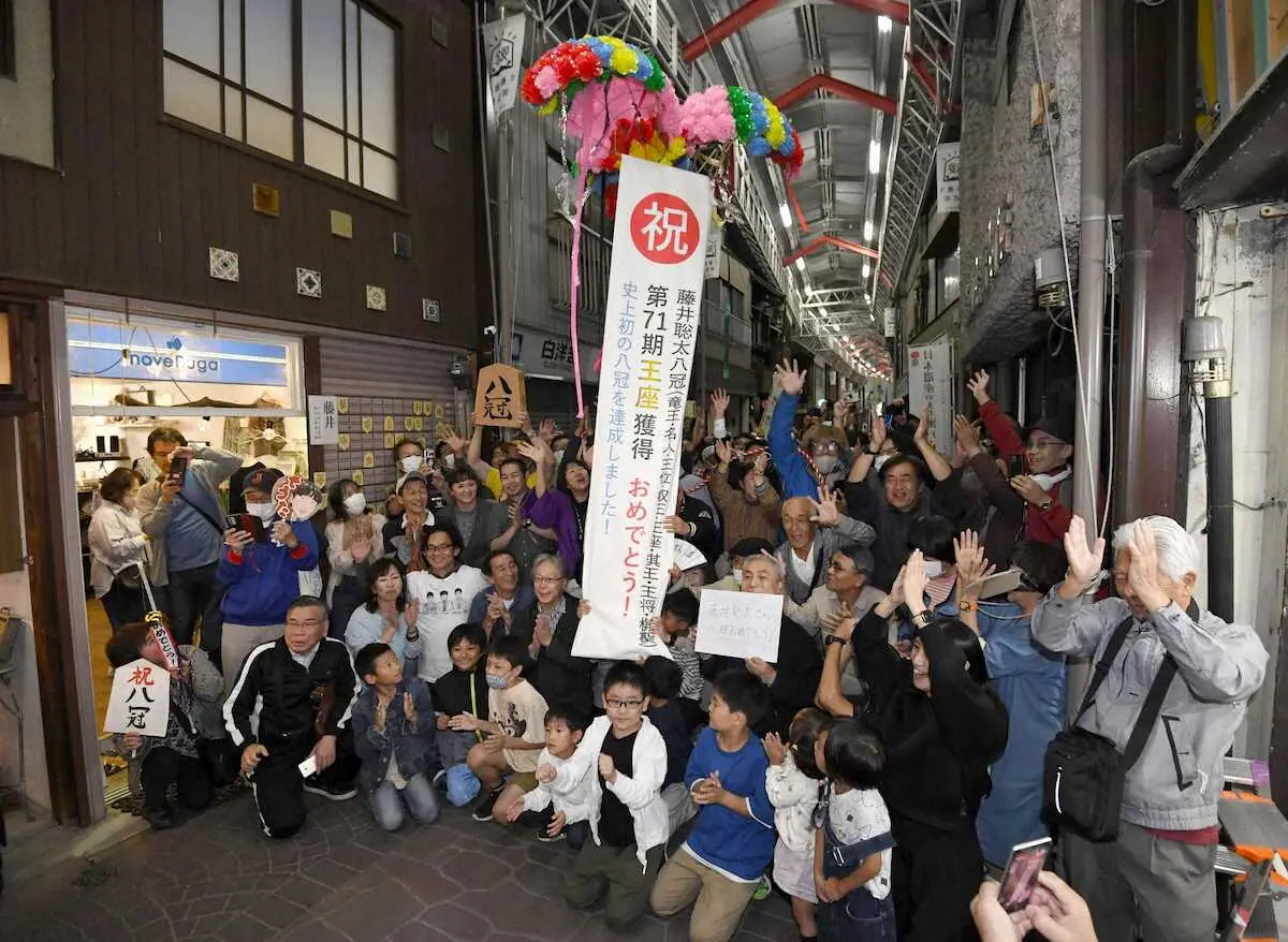 将棋の藤井聡太八冠誕生を地元、愛知県瀬戸市の商店街でくす玉を割り祝福する市民ら＝11日夜