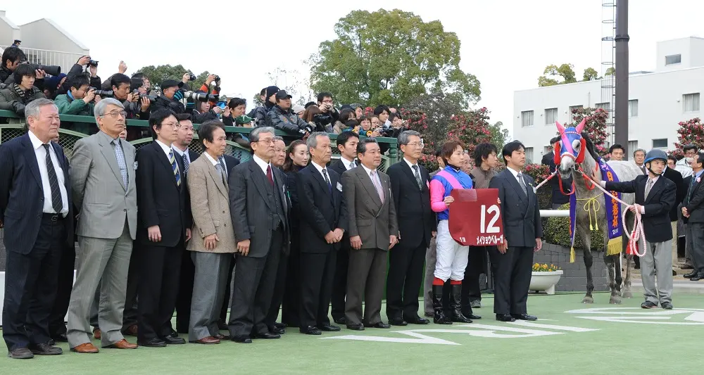 ＜第５７回日経新春杯・ＧⅡ＞口取り式で記念撮影に納まる優勝したメイショウベルーガ（牝５）と騎乗した池添謙一騎手（右から４人目）、管理する池添兼雄調教師（同６人目）ら関係者。