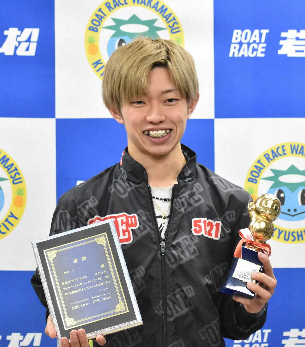 優勝の盾とトロフィーを手に笑顔の定松勇樹