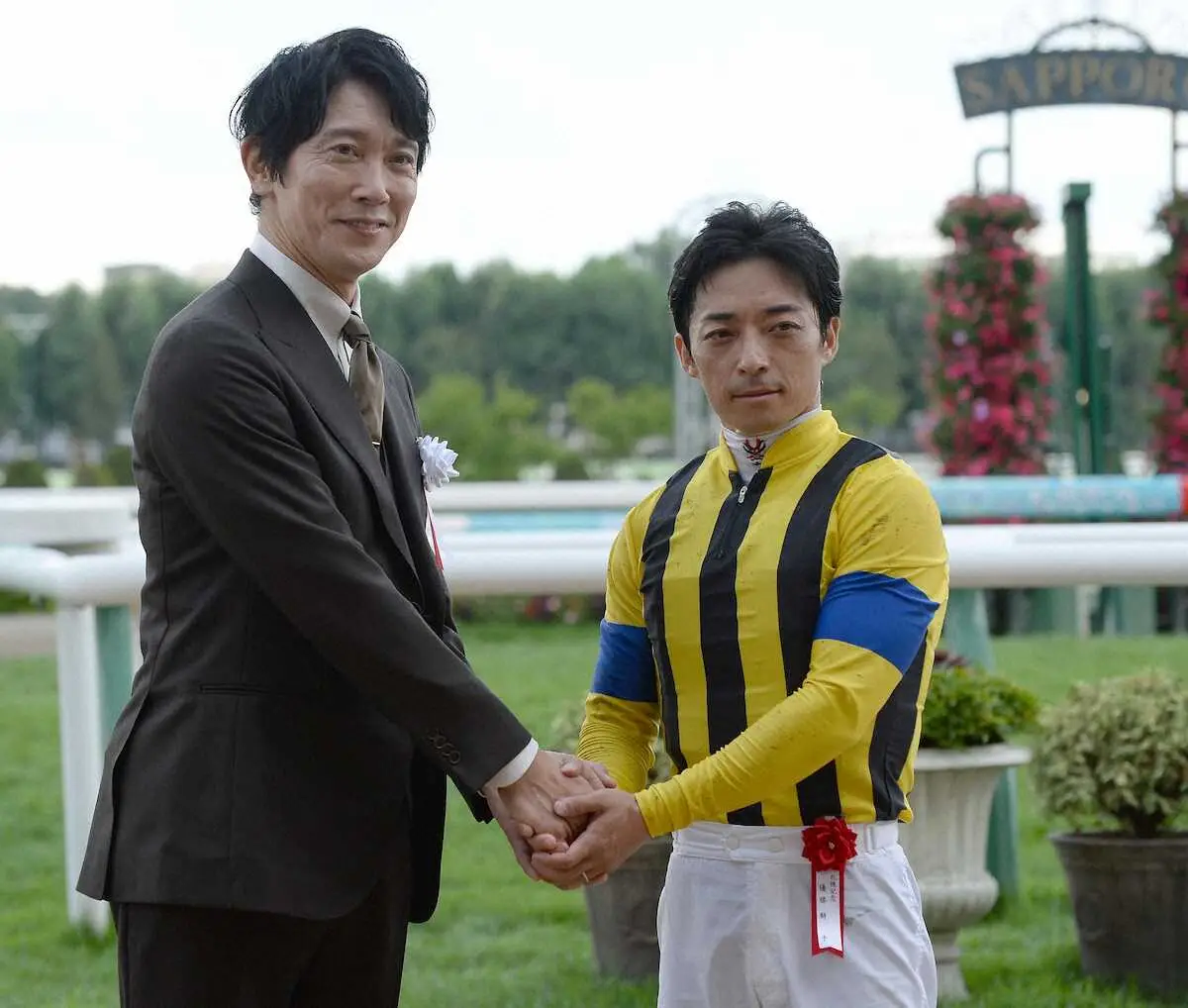 札幌記念をプログノーシスで制した川田将雅（右）はプレゼンターの佐々木蔵之介とがっちり握手（撮影・千葉　茂）
