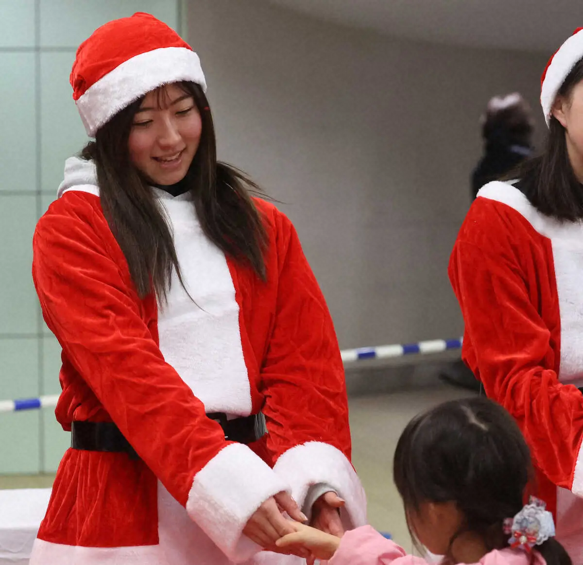 12月23日のイベントで、子どもたちにサンタ姿で握手する今村聖奈（撮影・亀井　直樹）