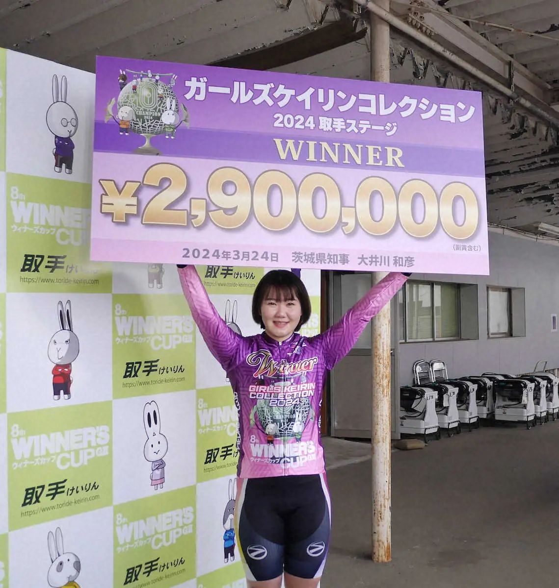 笑顔で賞金ボードを掲げる坂口楓華